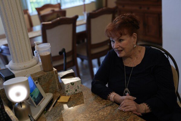 Deanna Dezern, 83 ans, invite son Elliq, à gauche, un appareil de table qui utilise l'intelligence artificielle pour mener des conversations humaines, pour parler aux journalistes en visite, à l'intérieur de sa maison à Tamarac, en Floride, le jeudi 7 décembre 2023. (AP Photo / Rebecca Blackwell)